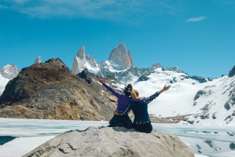 two friends have fun posing for a photo with Fitzroy Mountain in the background